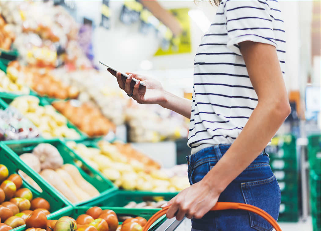 Women on phone in supermarket